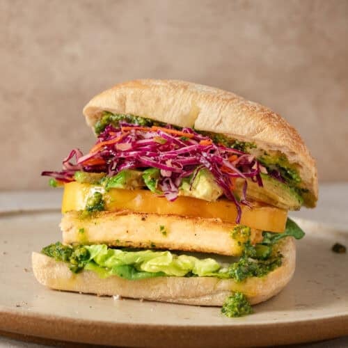 side view of crispy tofu sandwich on a plate.