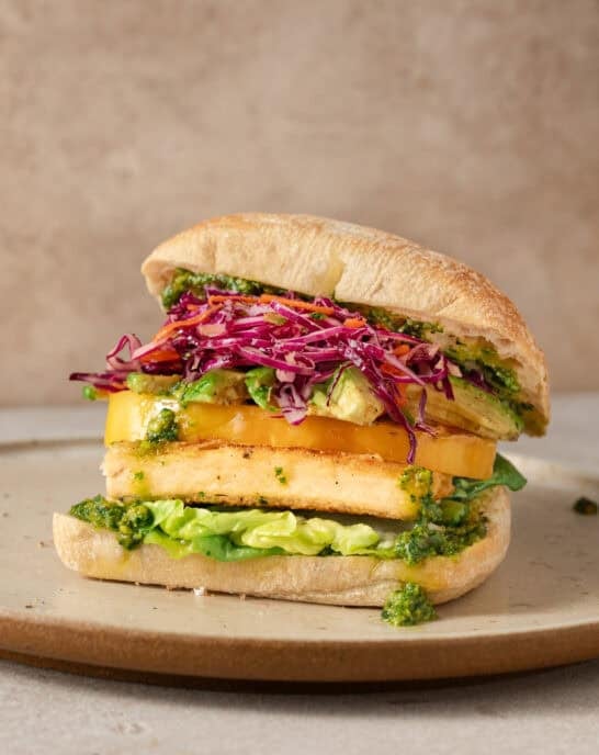 side view of crispy tofu sandwich on a plate.
