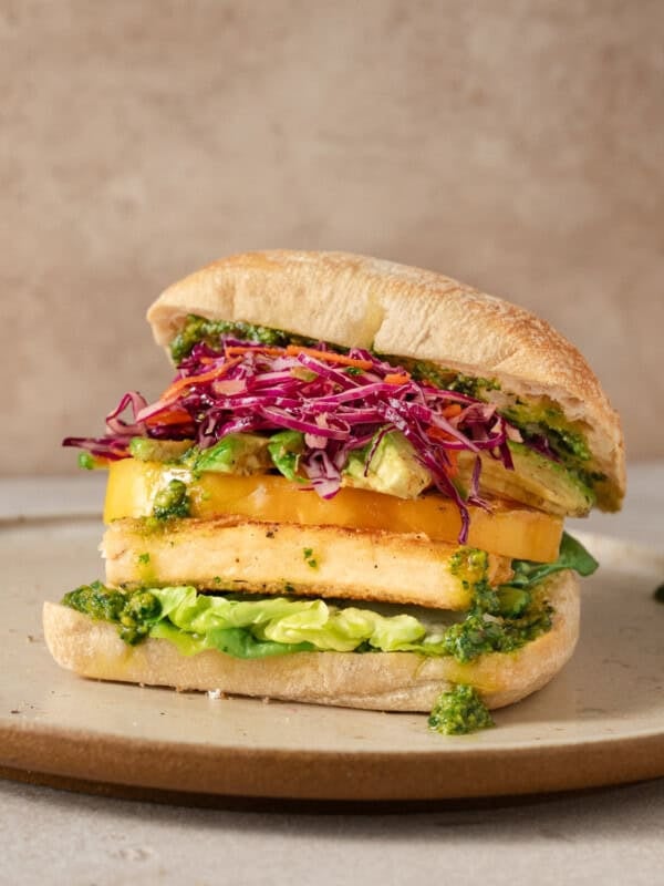 side view of crispy tofu sandwich on a plate.