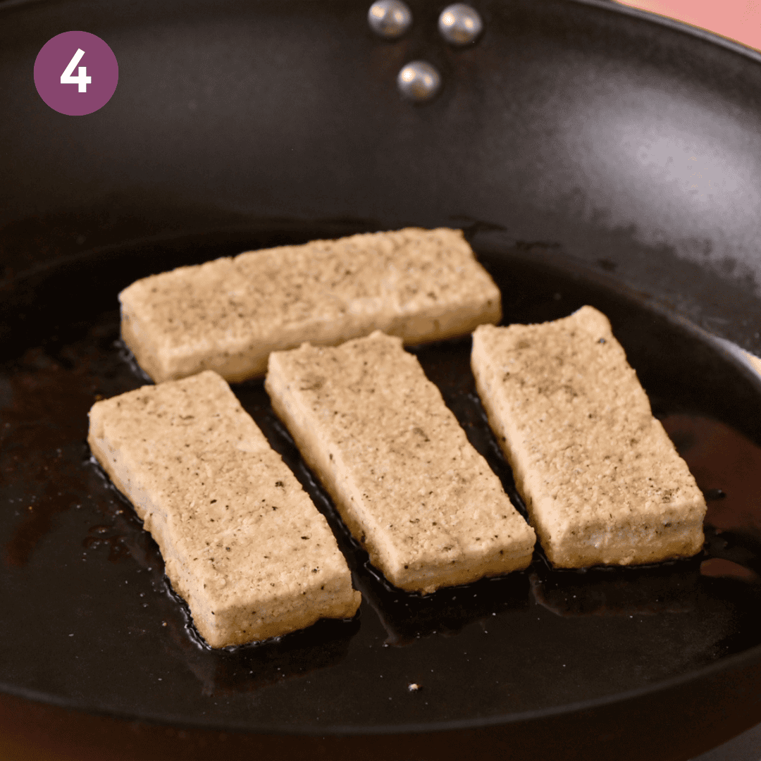 Battered tofu in pan before being fried.