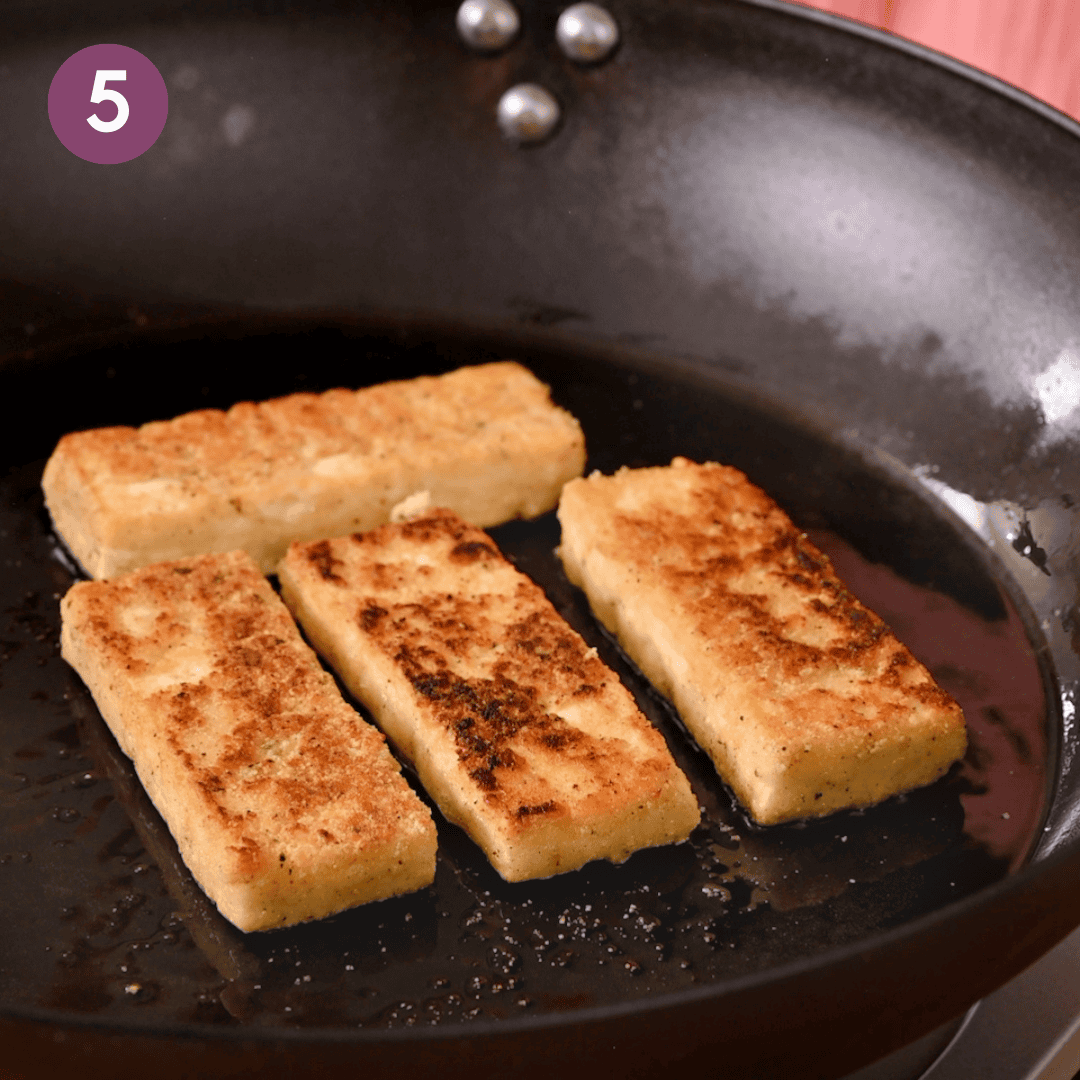 Flipped battered tofu in pan after the first side was fried.