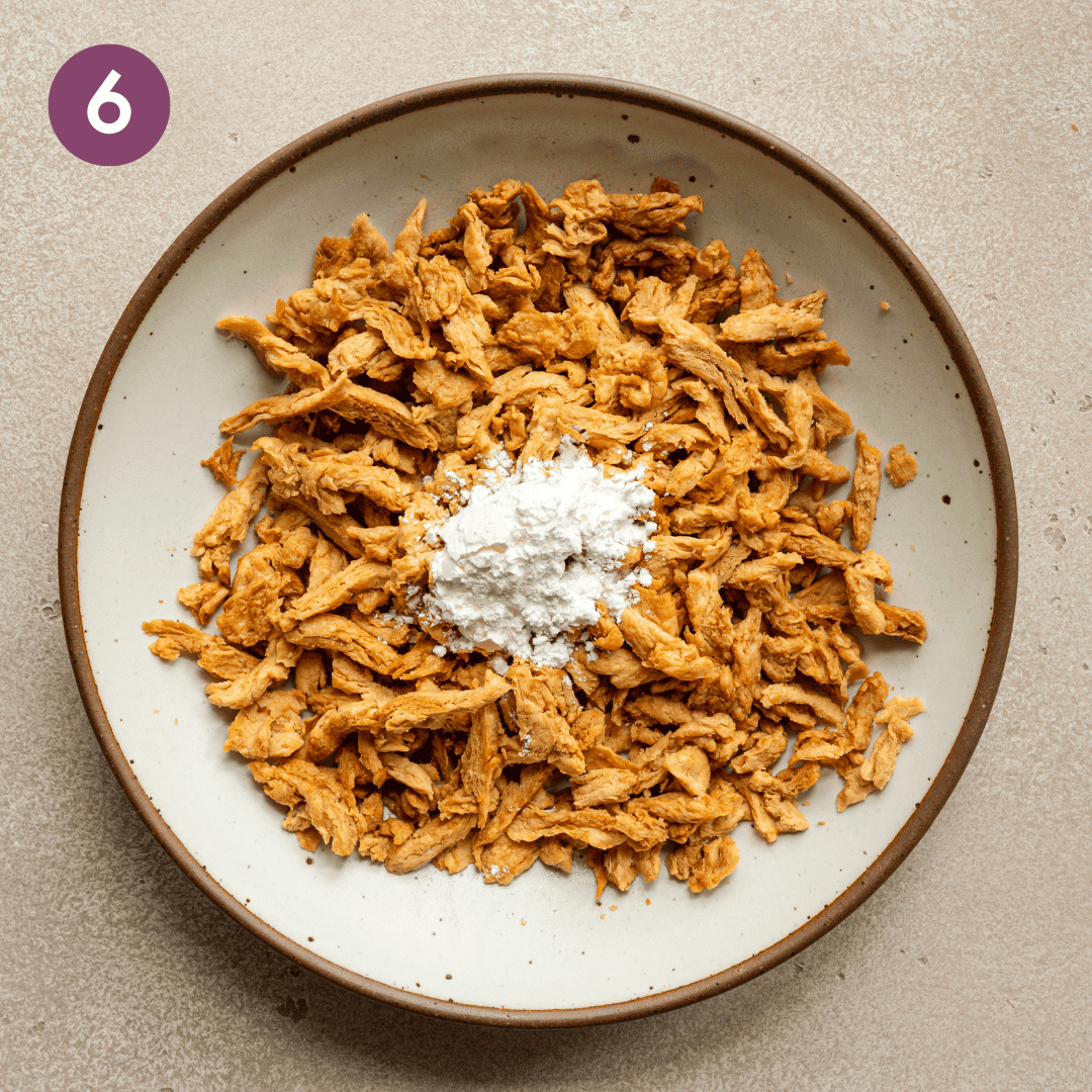 cornstarch added to sliced soy curls in bowl.
