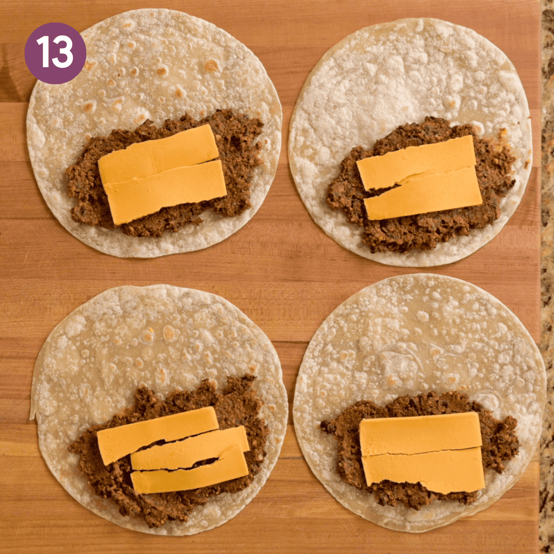 black bean taco filling and vegan cheese on one half of a tortilla.