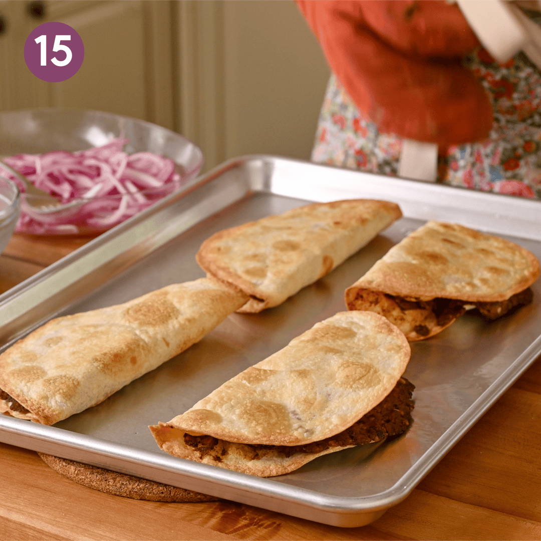 cooked crispy black bean tacos on a sheet pan.