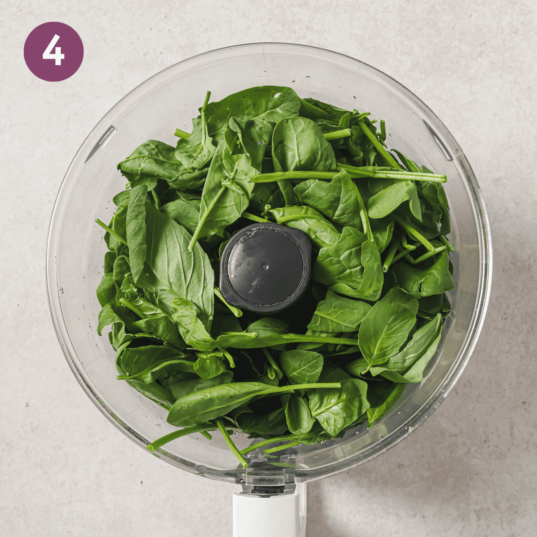 basil and spinach added to garlic walnut mixture before being blitzed.