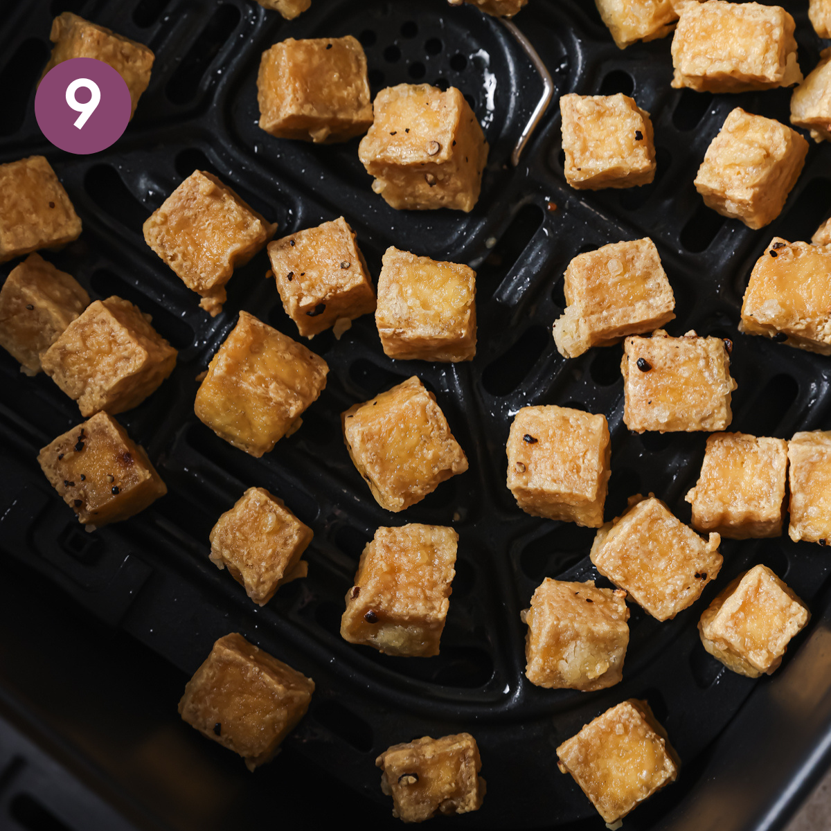 close up of cooked tofu cubes in the air fryer.
