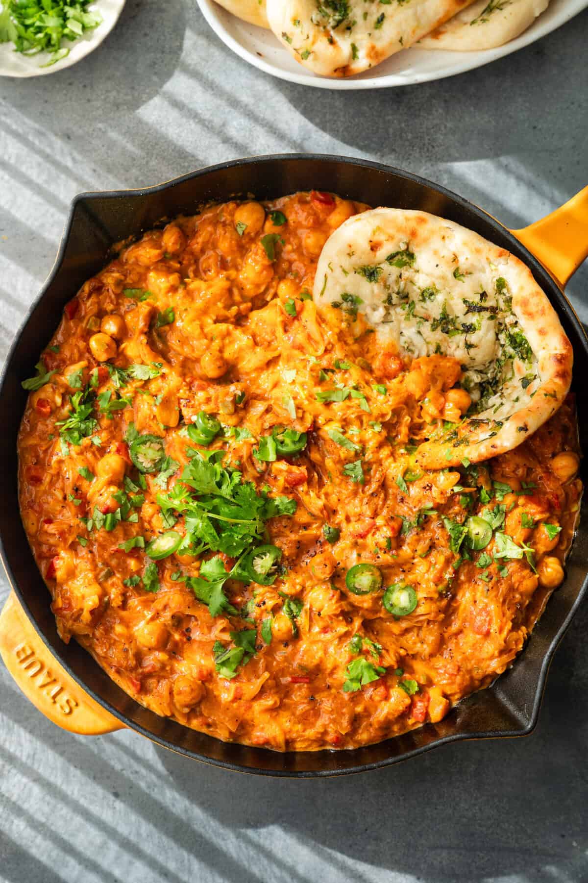 overhead view of cabbage curry and naan in a skillet.