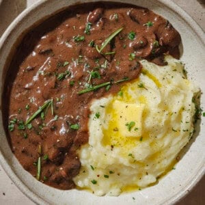 Gravy and mashed potatoes with a pat of butter in a bowl.