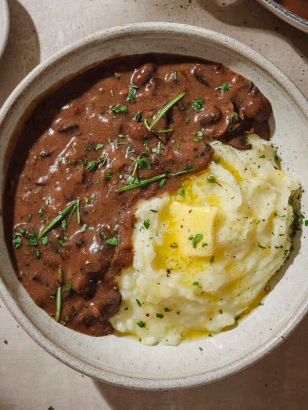 Gravy and mashed potatoes with a pat of butter in a bowl.