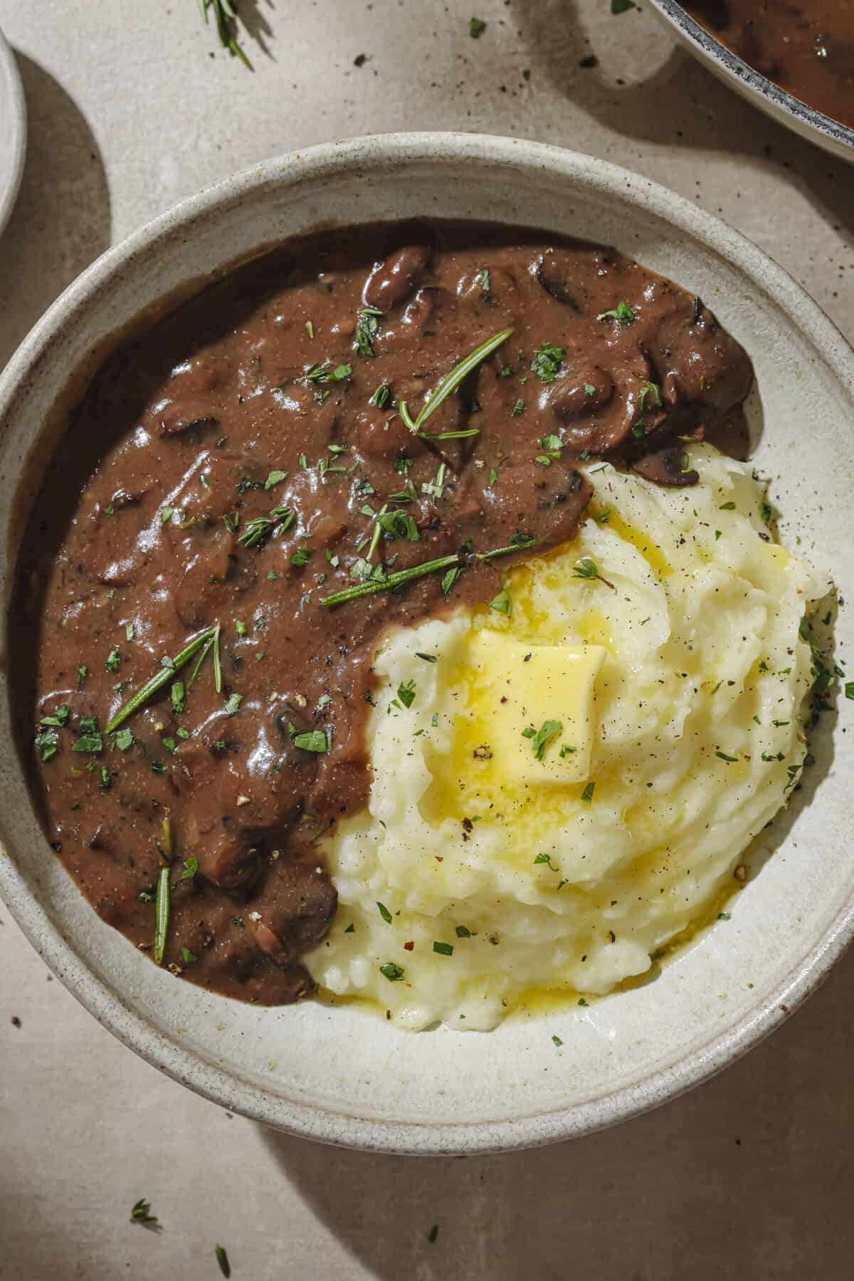 Gravy and mashed potatoes with a pat of butter in a bowl.