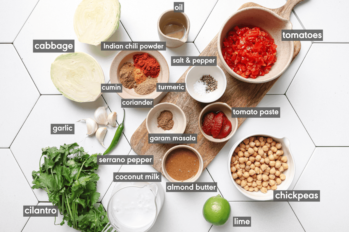 cabbage curry ingredients in various bowls on a white tiled table.