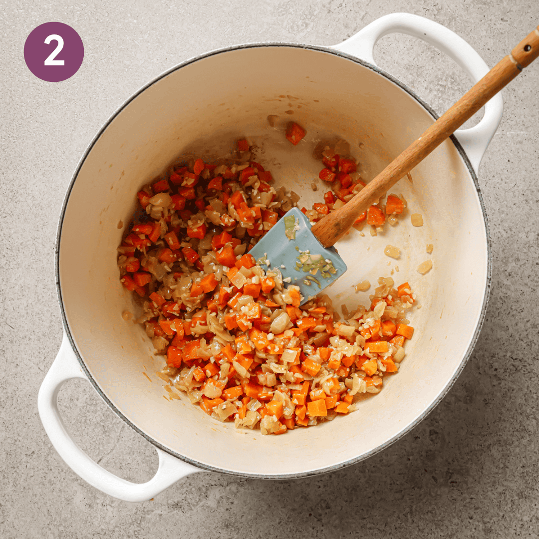 carrots, garlic and preserved lemon added to sauteed onions in a dutch oven.