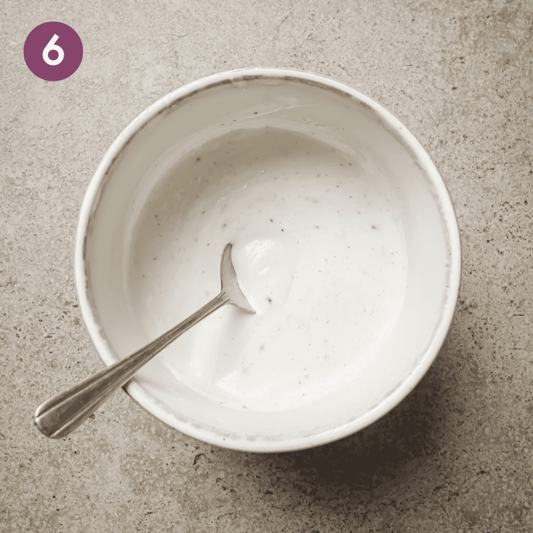 yogurt sauce with a spoon in a small white bowl.