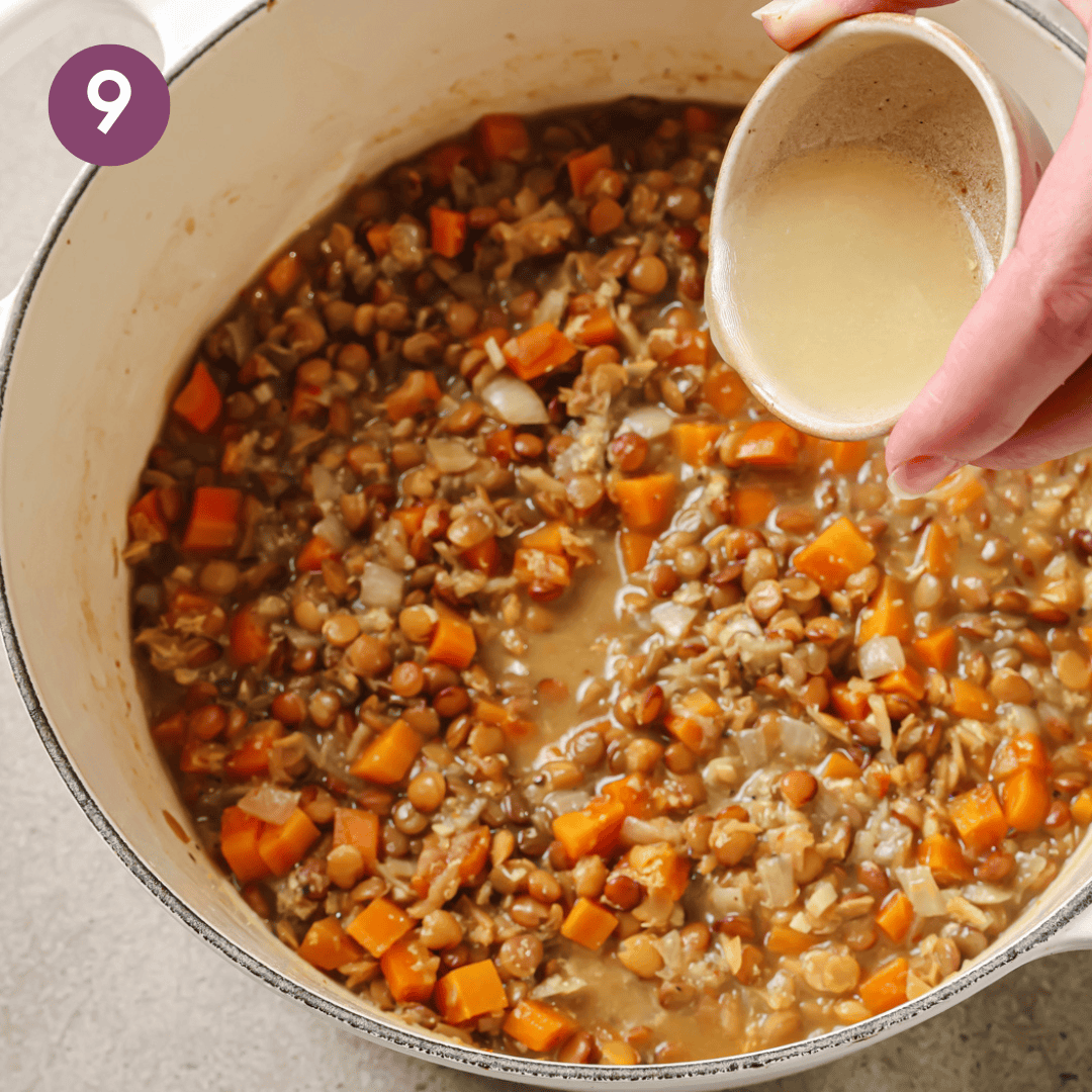 woman's hands pouring lemon juice into cooked lentil soup.