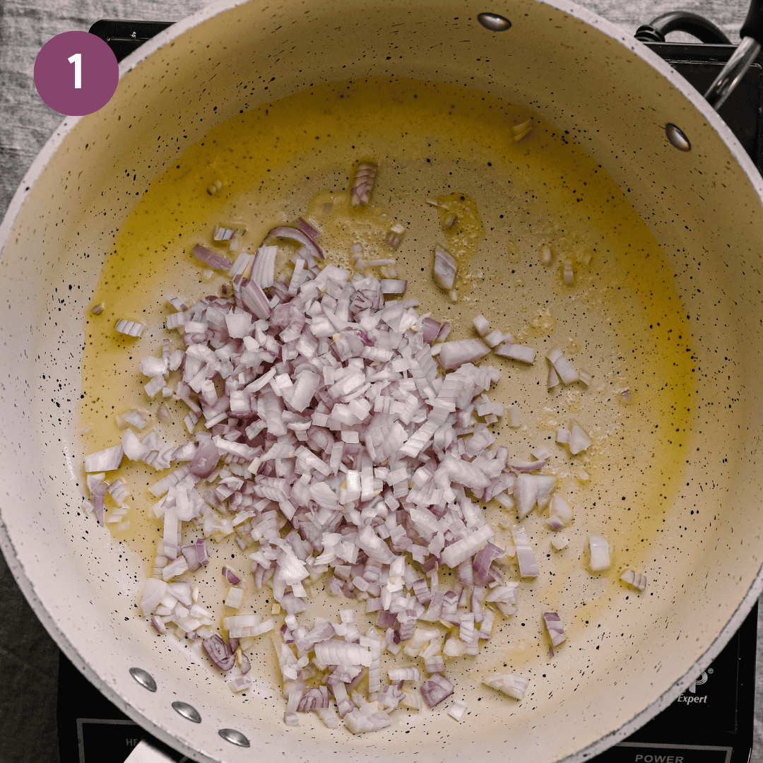 shallots and oil cooking in a frying pan.