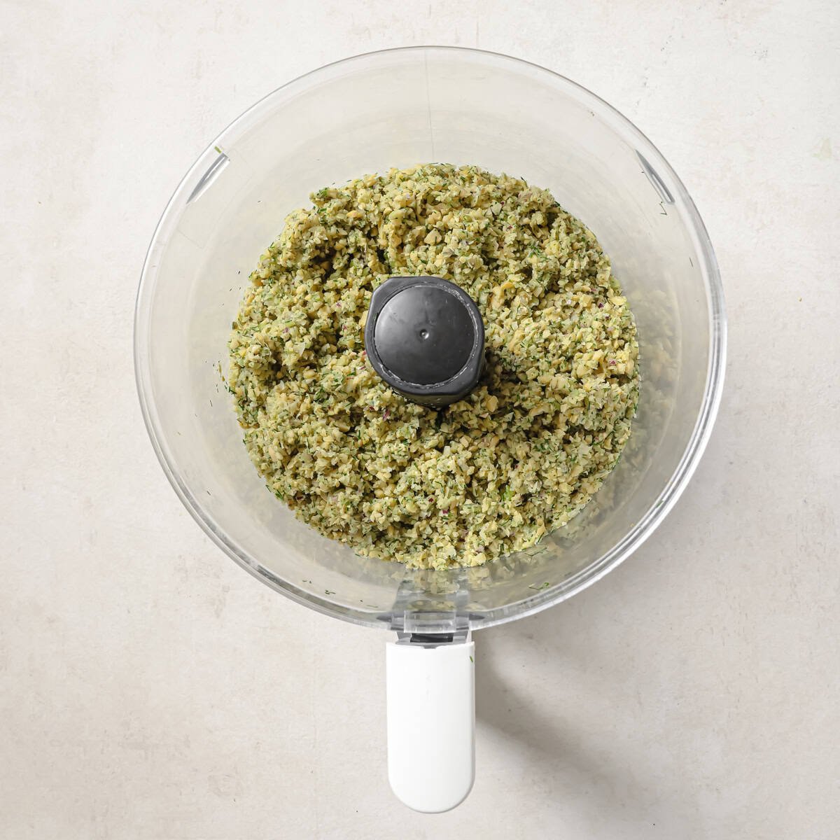 chickpea mixture in food processor after it's been pulsed together.