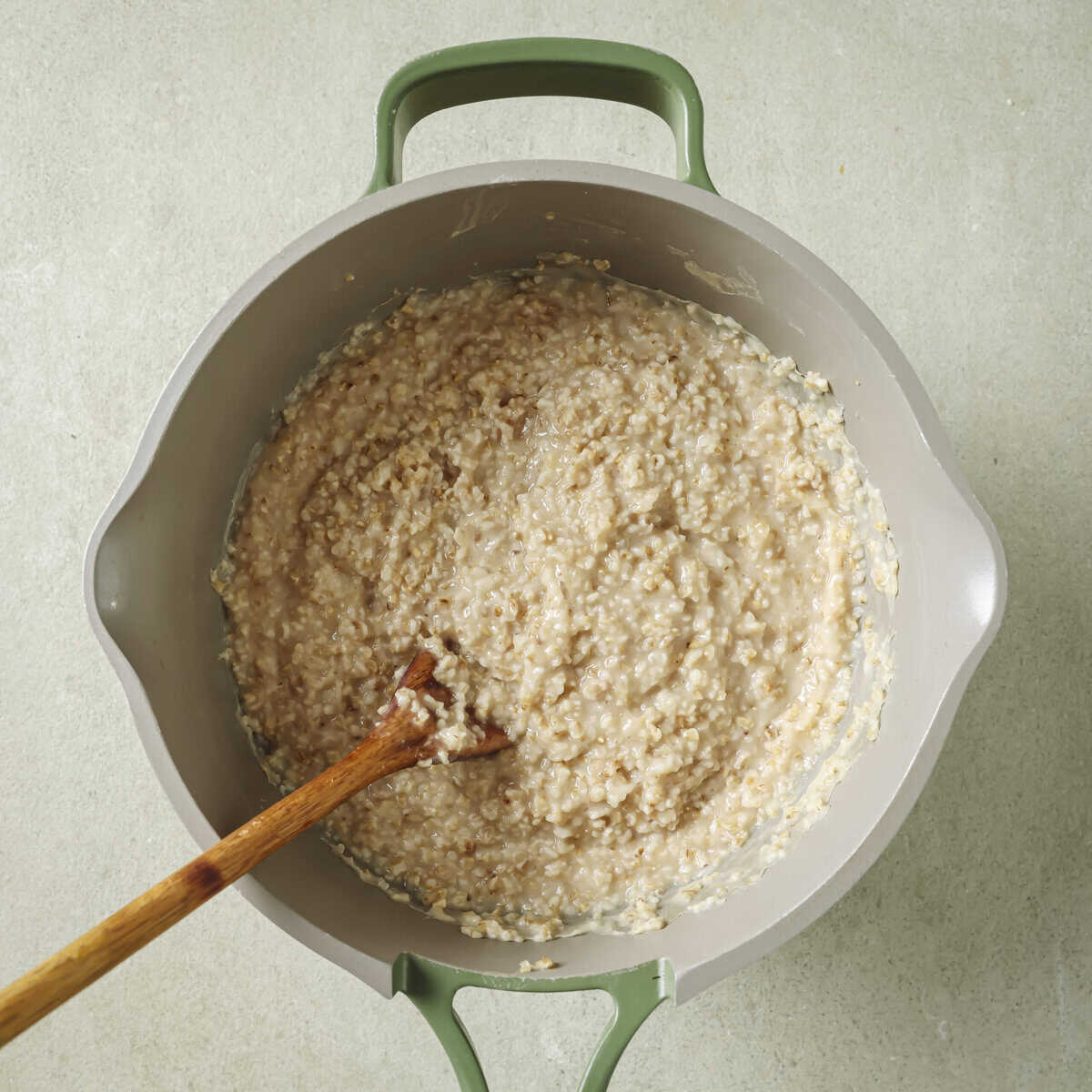 wooden spoon in pot of cooked oats.
