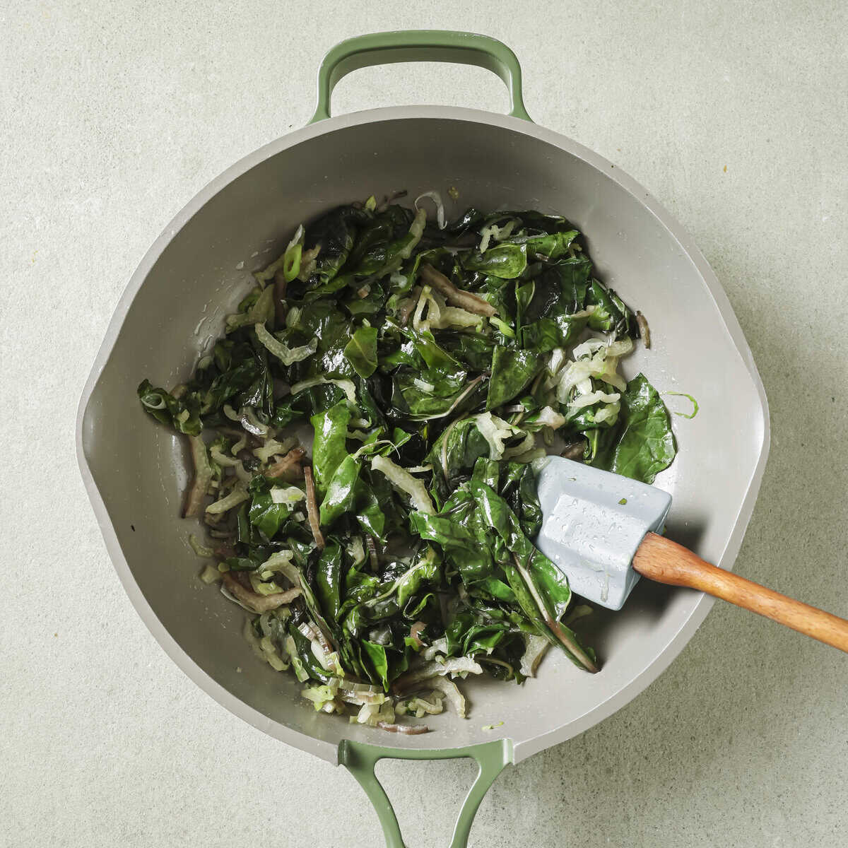 swiss chard and scallions cooking in a saucepan.