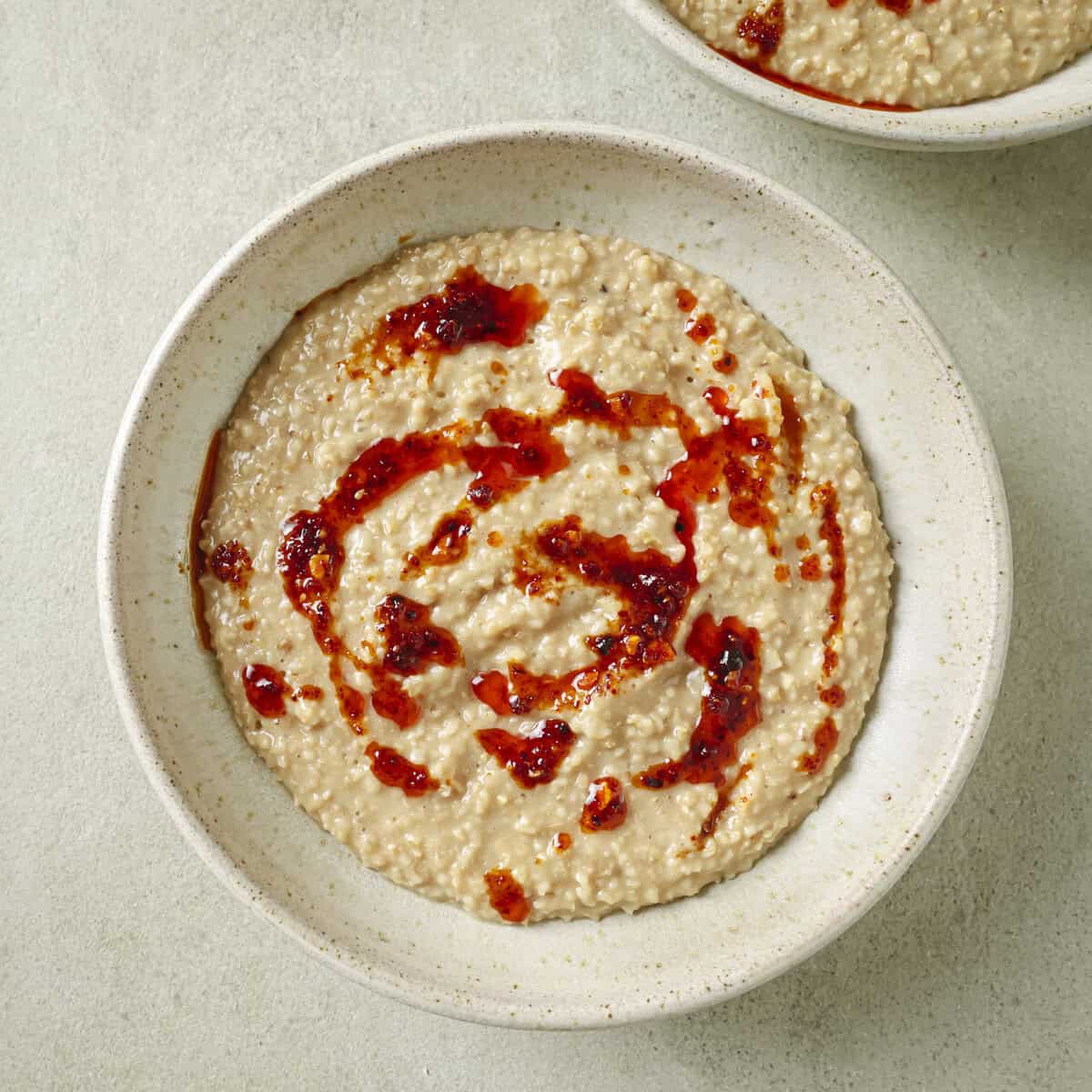 bowl of cooked savory oatmeal with chili crisp on it.