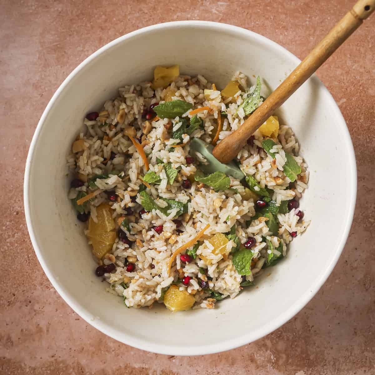 orange pieces, pomegranate seeds, dates and mint folded into the rice.