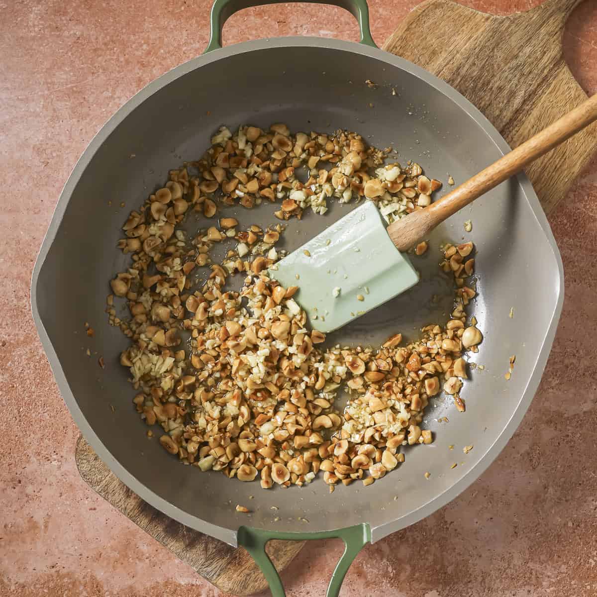 chopped garlic added to the toasted hazelnuts in the pan.