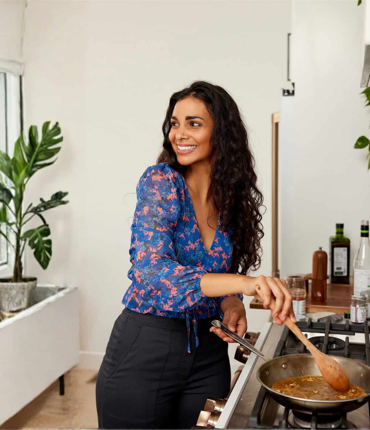 a woman stirring a pan of food.