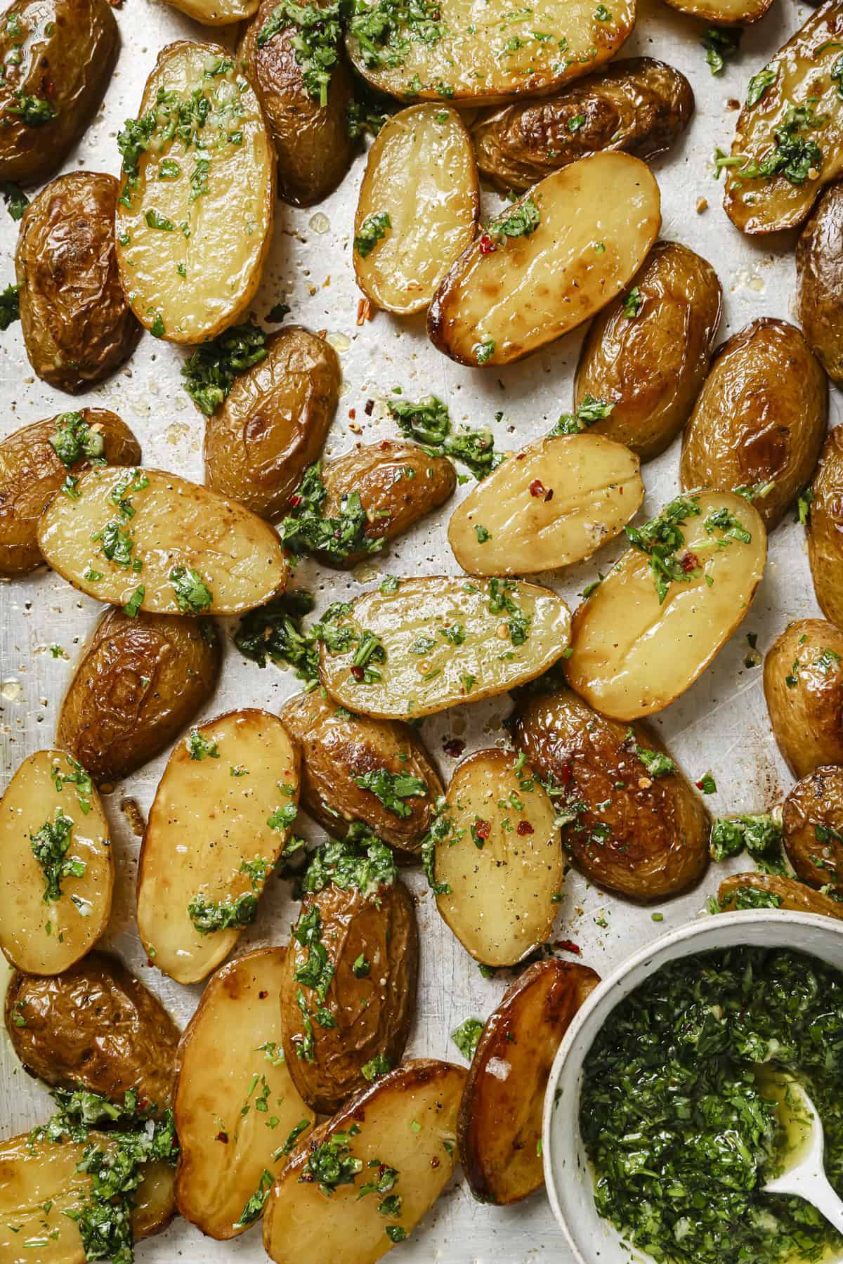 sheet pan with roasted potatoes covered in gremolata.