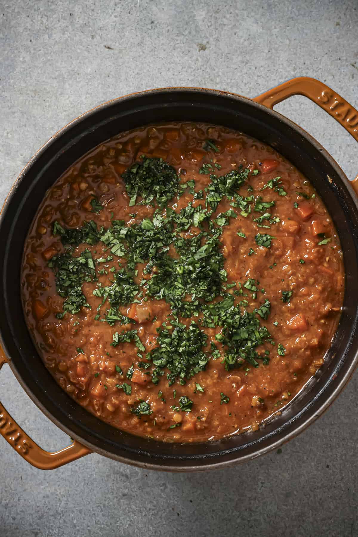 Close up photo of the finished pot of soup topped with olive oil and fresh mint.