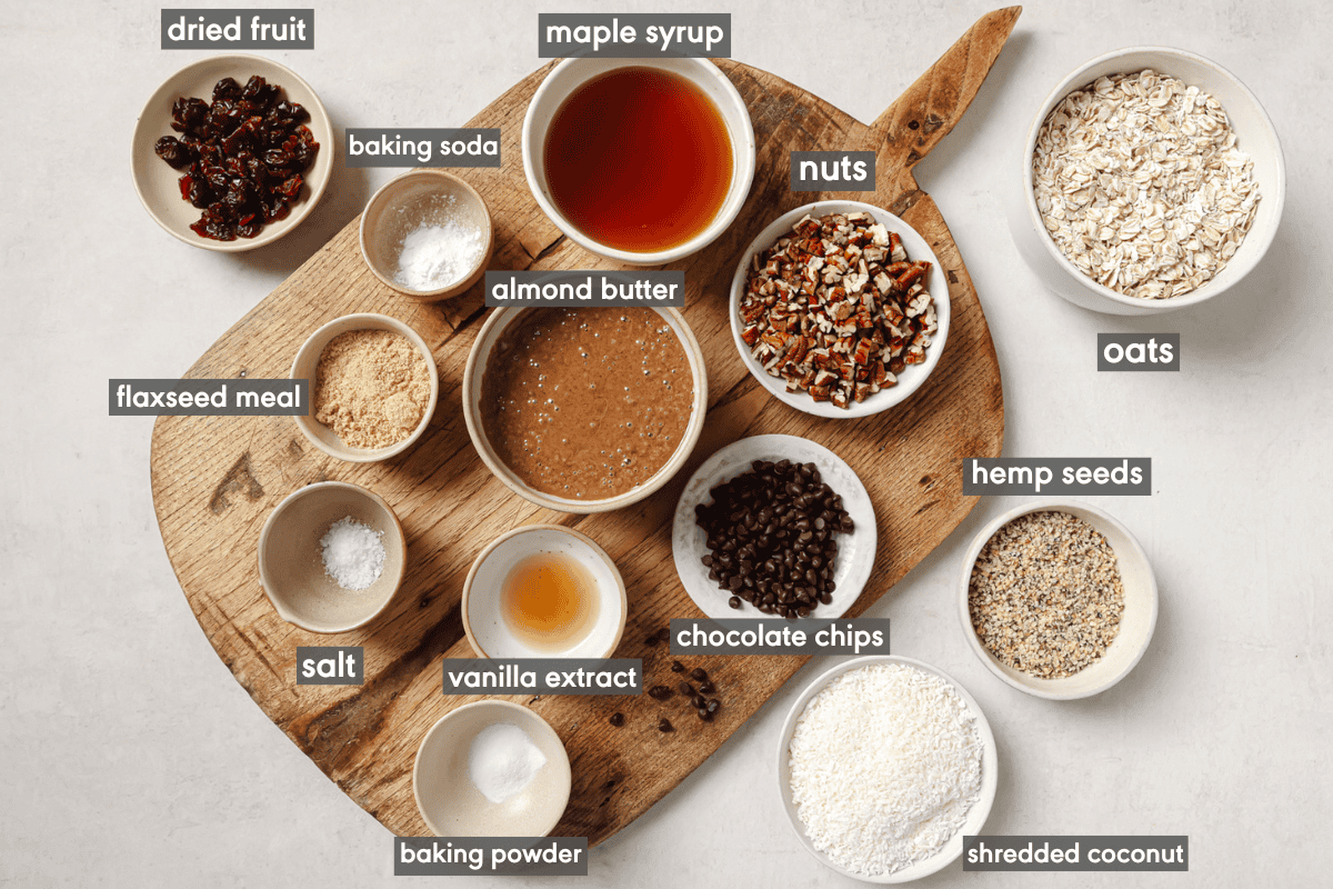 ingredients for breakfast cookies in various small bowls on a wooden cutting board.