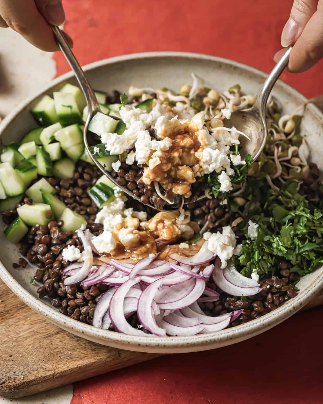 person tossing salad with sesame miso dressing.