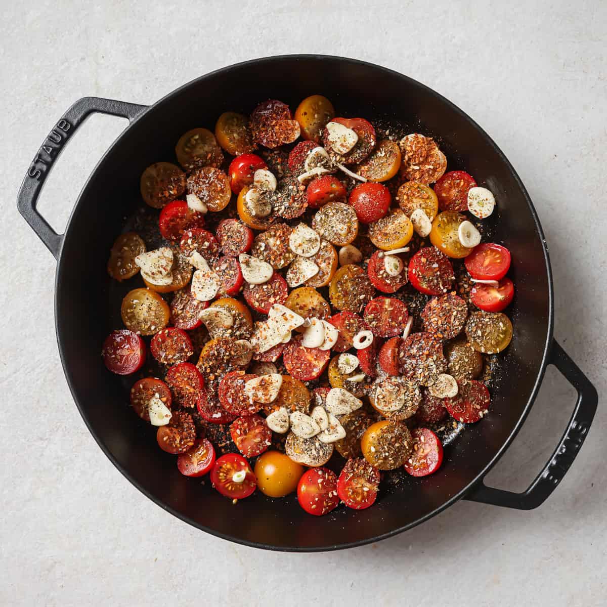confited tomato ingredients minus the oil in a baking dish.