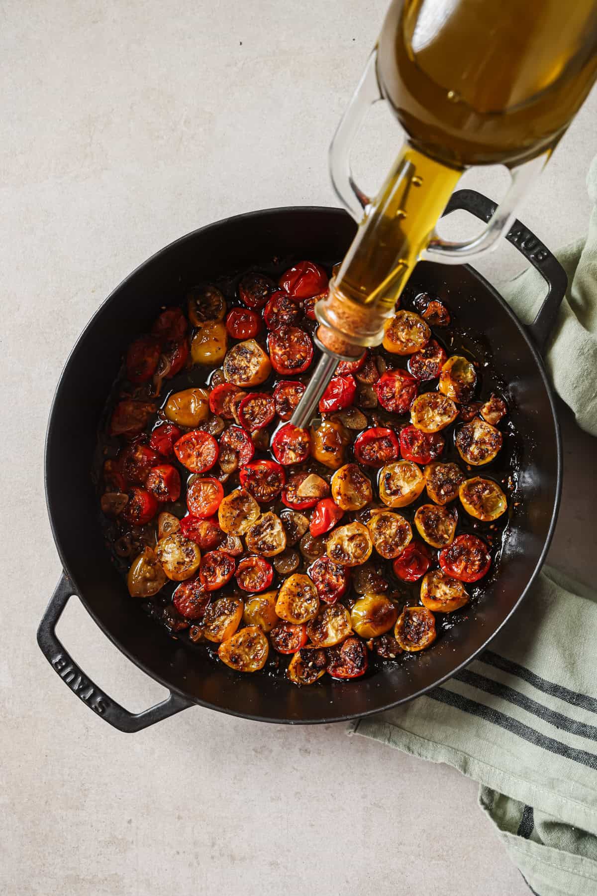 person adding the remaining olive oil to the pan before baking again.