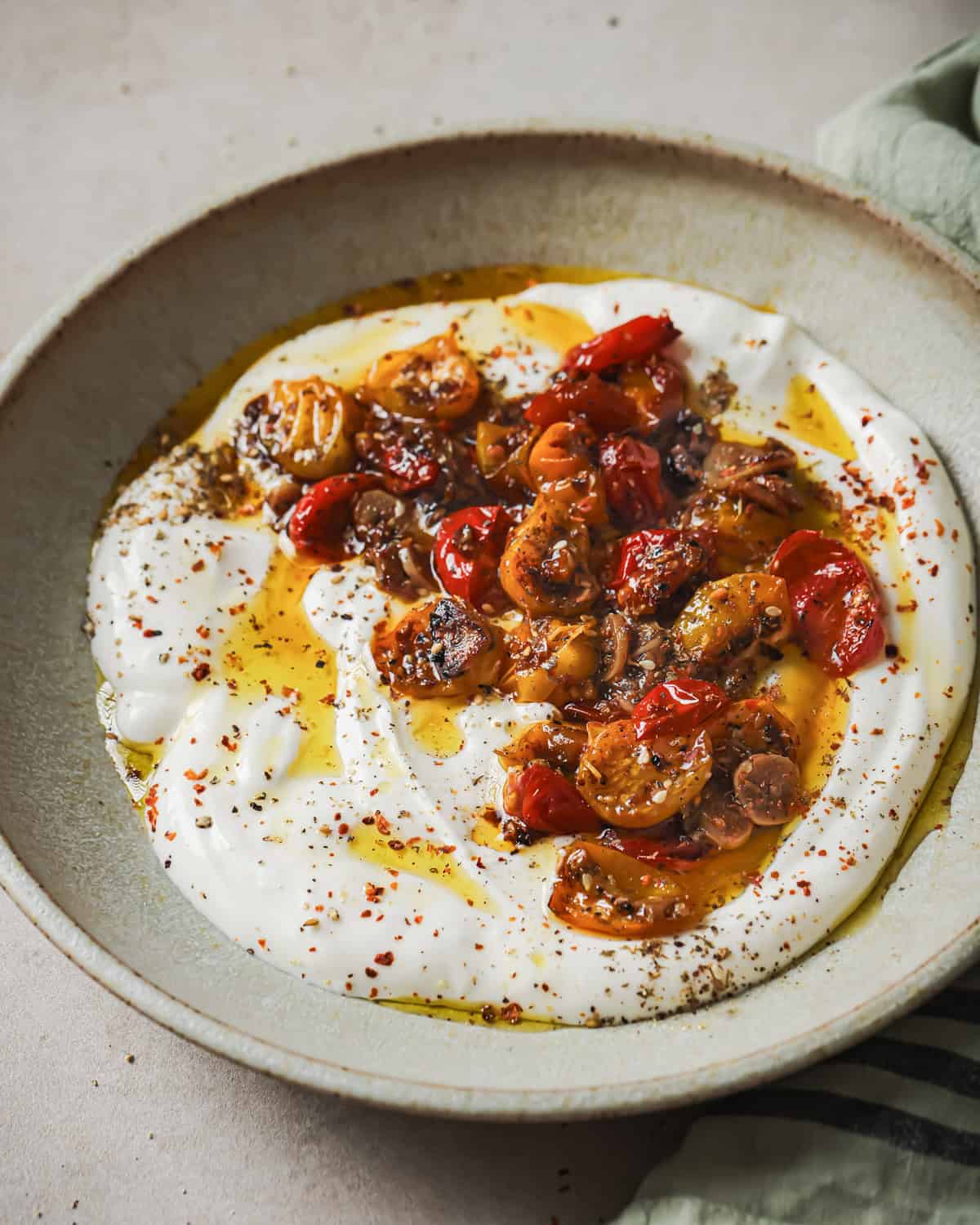 vegan yogurt, herbs and confited tomatoes with their oil in a bowl.
