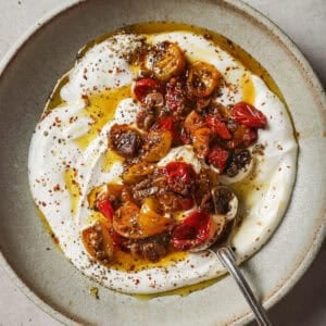 vegan yogurt, spices and confited tomatoes with their oil in a bowl.