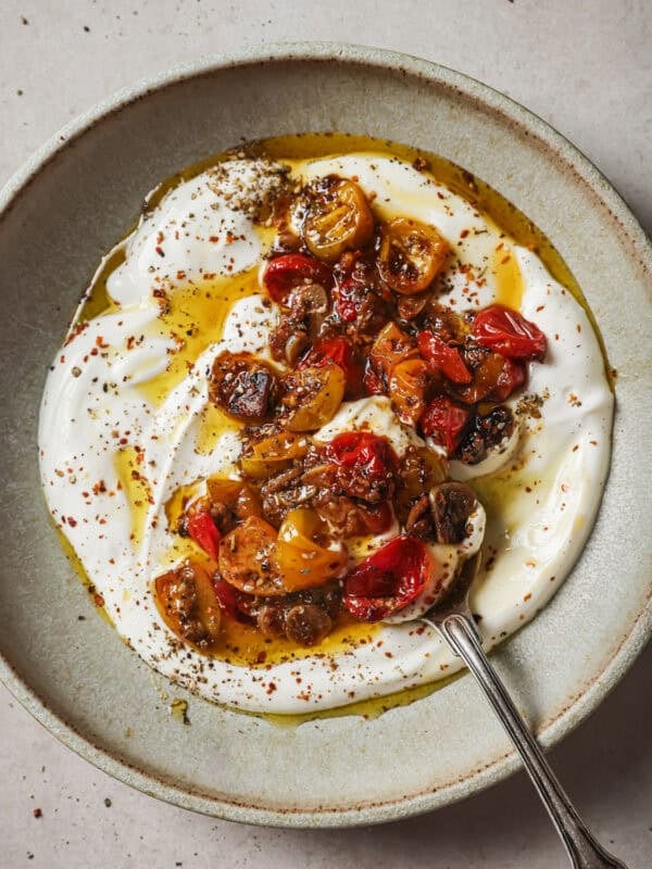 vegan yogurt, spices and confited tomatoes with their oil in a bowl.