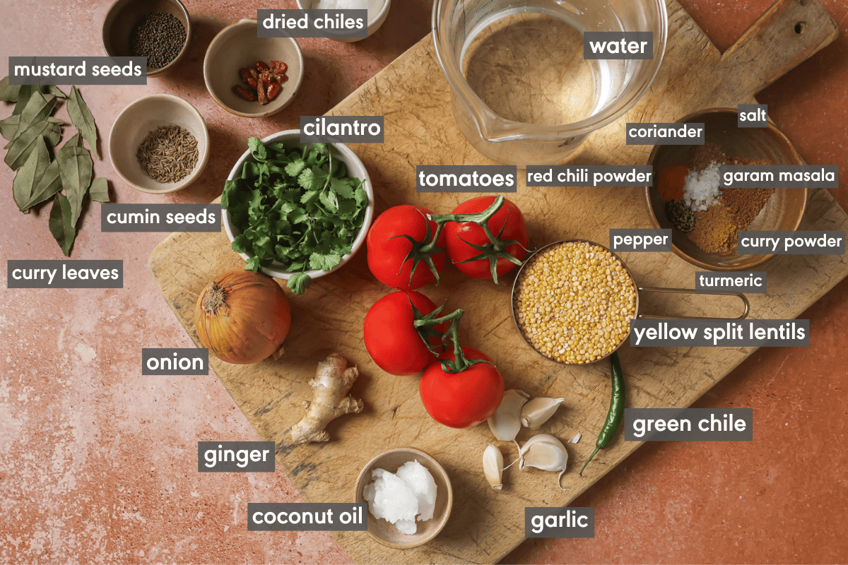ingredients for dal tadka in various small bowls on a table.