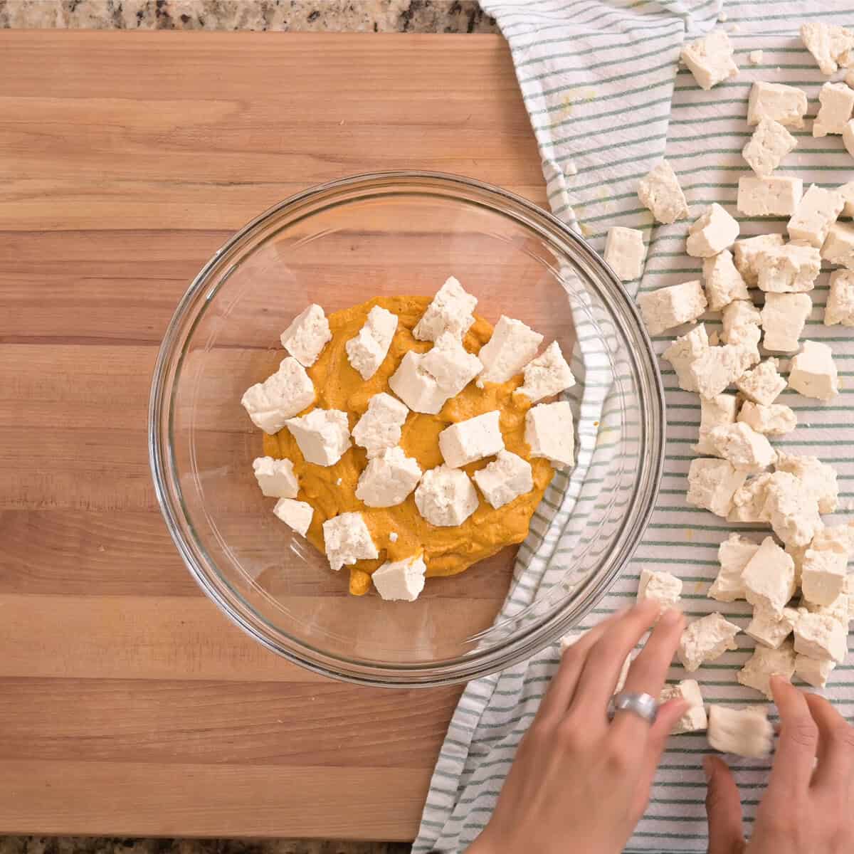 tofu chunks on top of marinade in bowl.