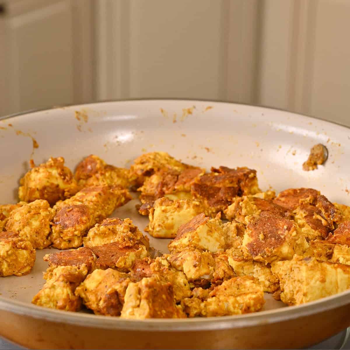 flipped golden tofu in a pan.