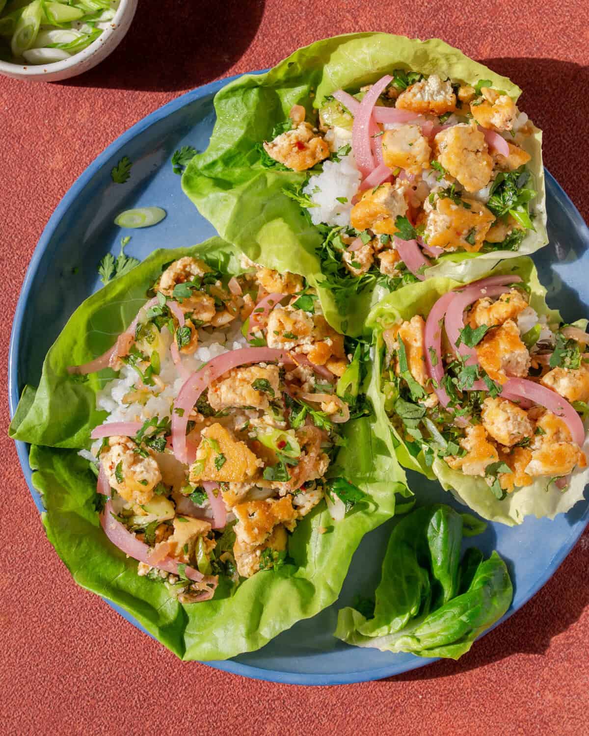 three thai laab salad lettuce cups on a plate.