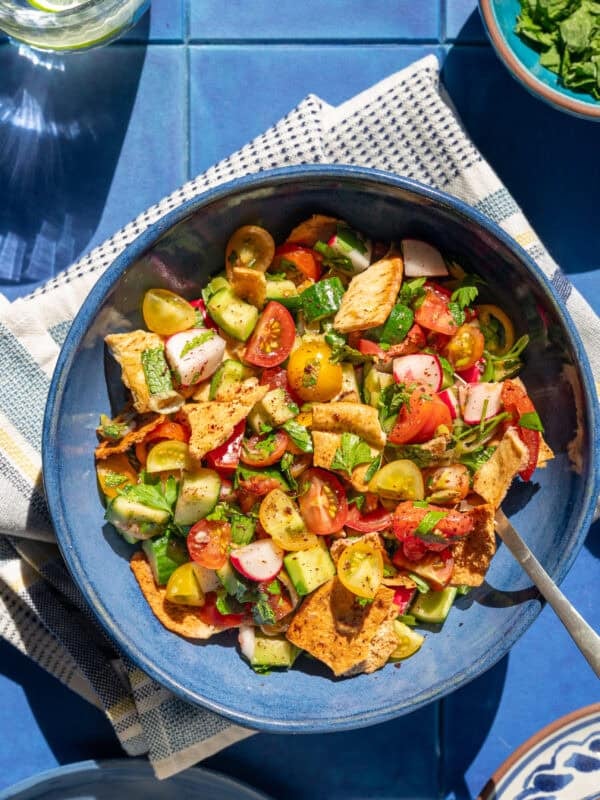 bowl of fattoush on a cloth napkin on a table.