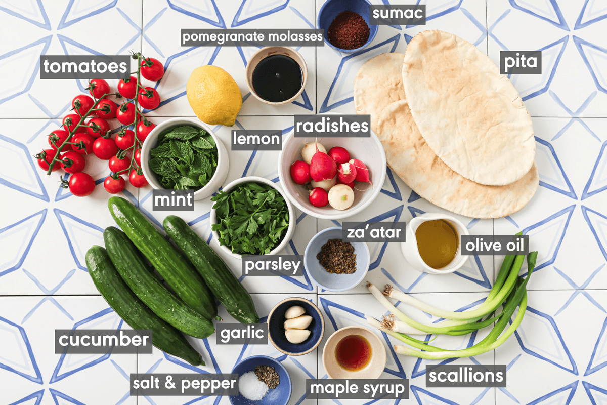 Ingredients for Fattoush Salad laid out in bowls on white & blue background.