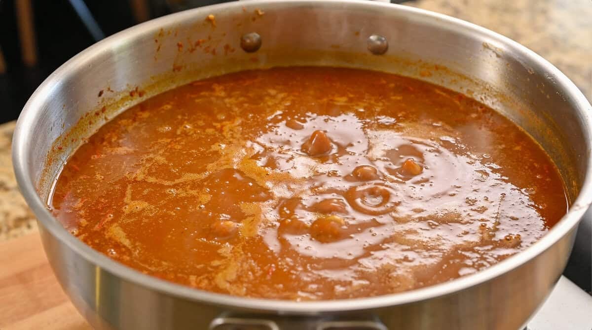 stirred combined rajma masala ingredients in the deep frying pan.