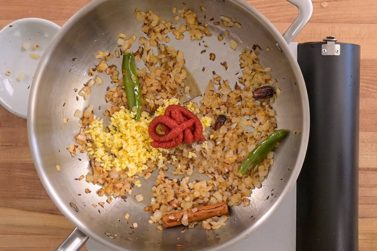 garlic-ginger paste and tomato paste added to the frying pan.
