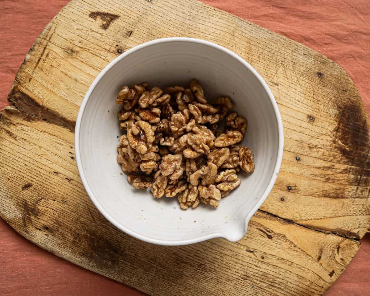 small bowl of walnuts on a cutting board.