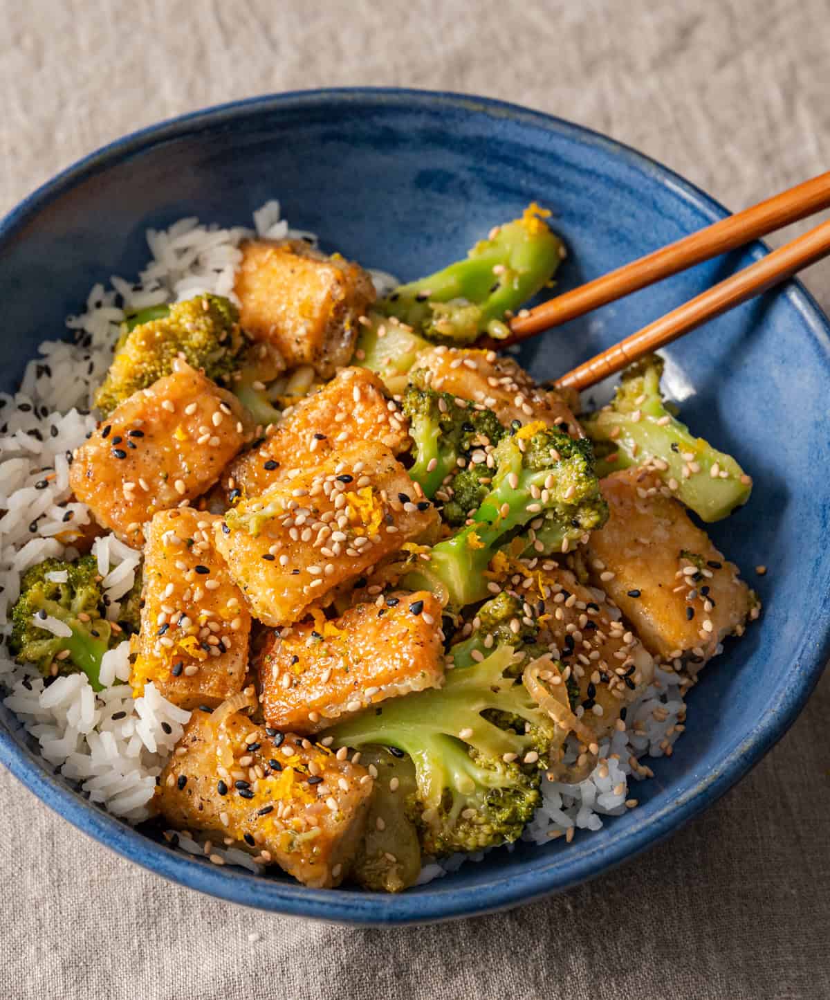 tofu and broccoli stir fry on a bed of rice in a bowl.