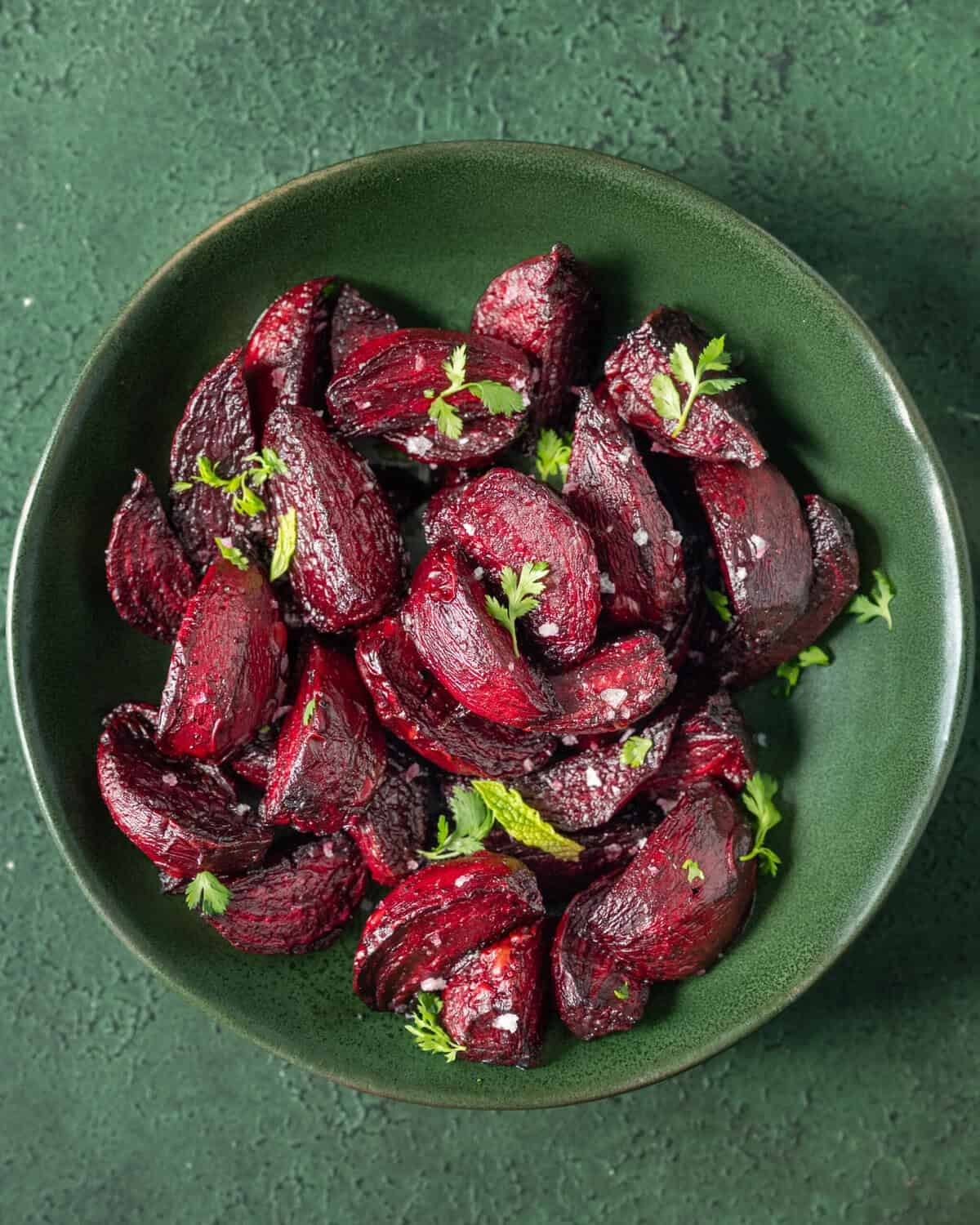 Roasted beets topped with flaky salt and parsley in a bowl.