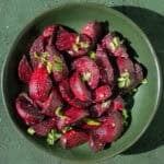 Roasted beets topped with flaky salt and parsley in a bowl.