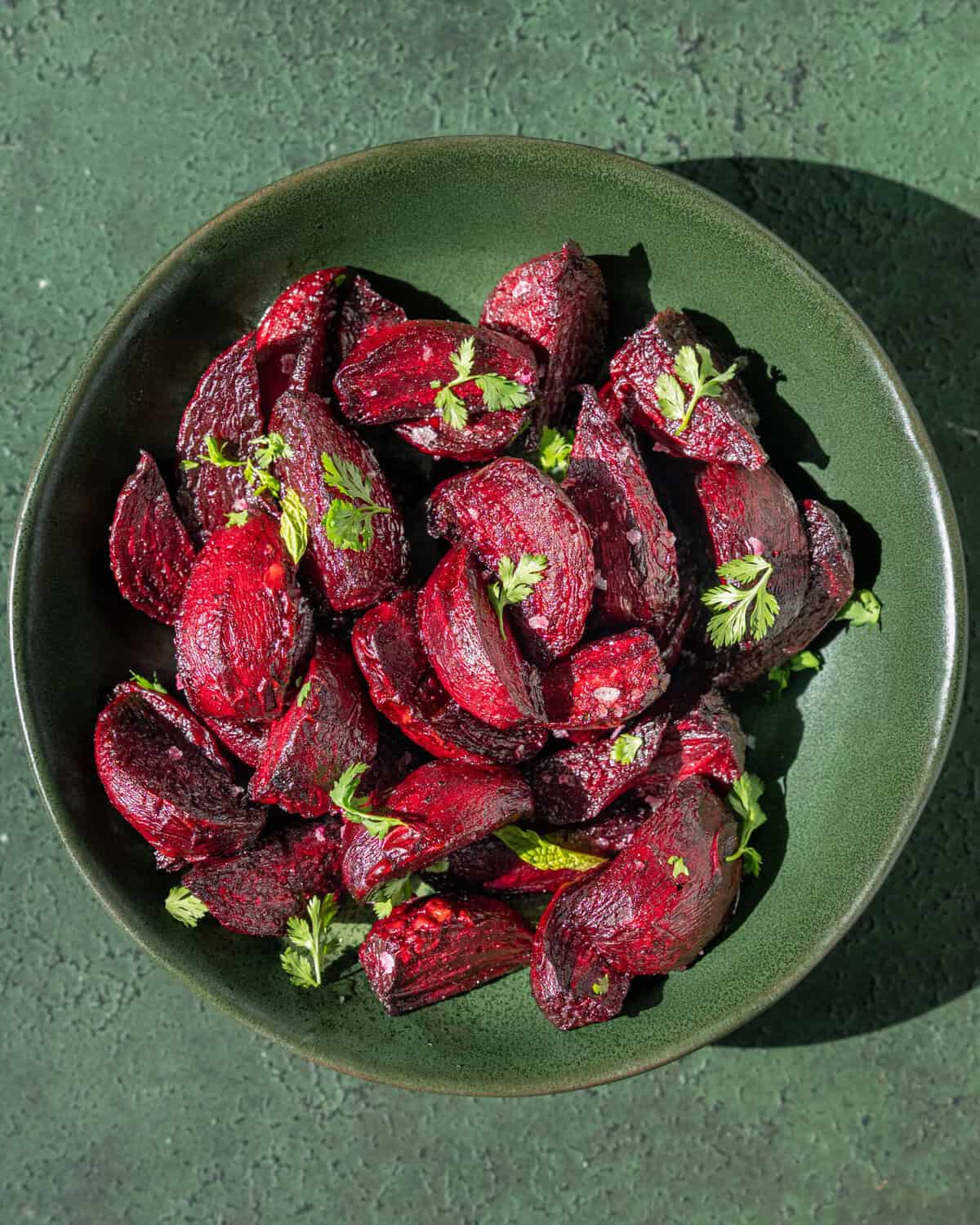 Roasted beets topped with flaky salt and parsley in a bowl.