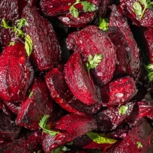 close up of roasted chopped beets with flaky salt and bits of parsley.