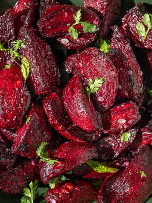close up of roasted chopped beets with flaky salt and bits of parsley.